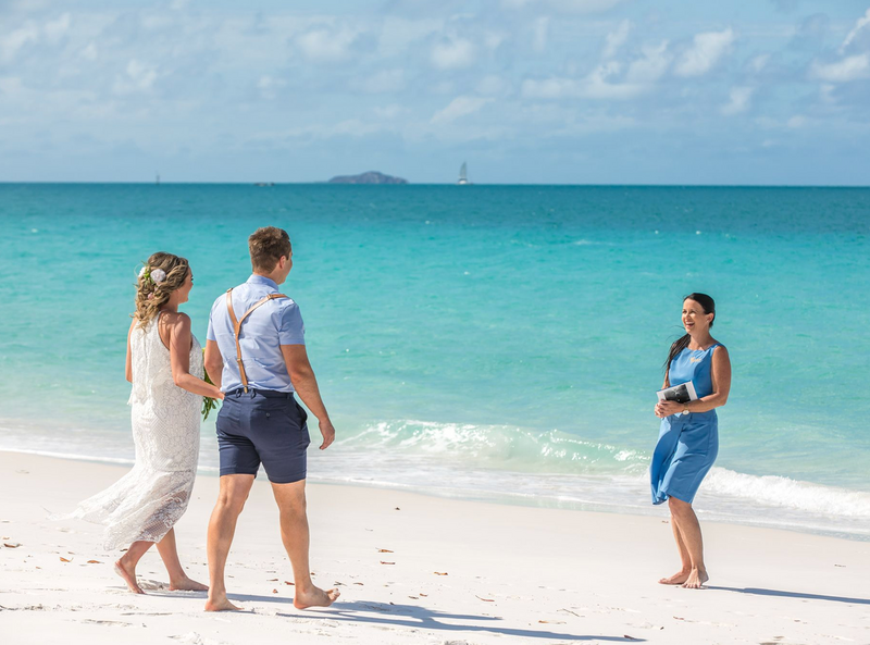 A bride and groom with a celebrant eloping on whitehaven beach queensland