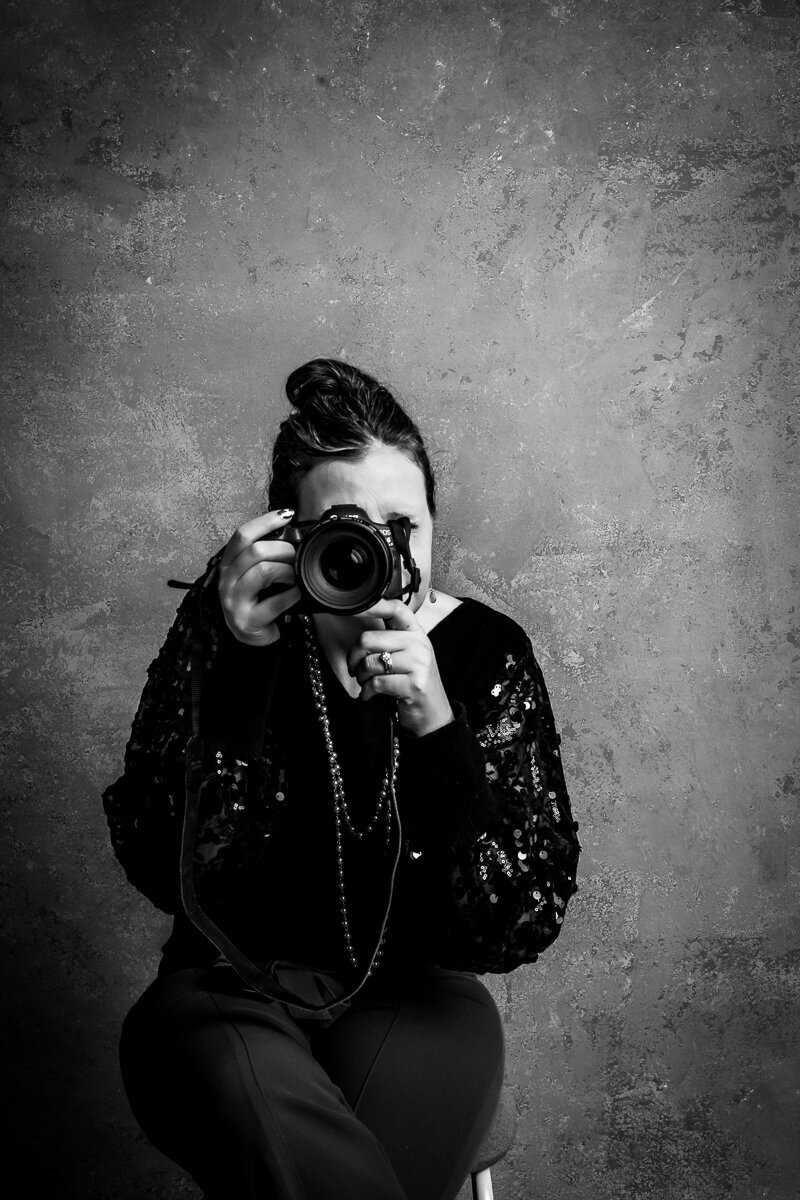 Black and white headshot image of high shooting with her camera