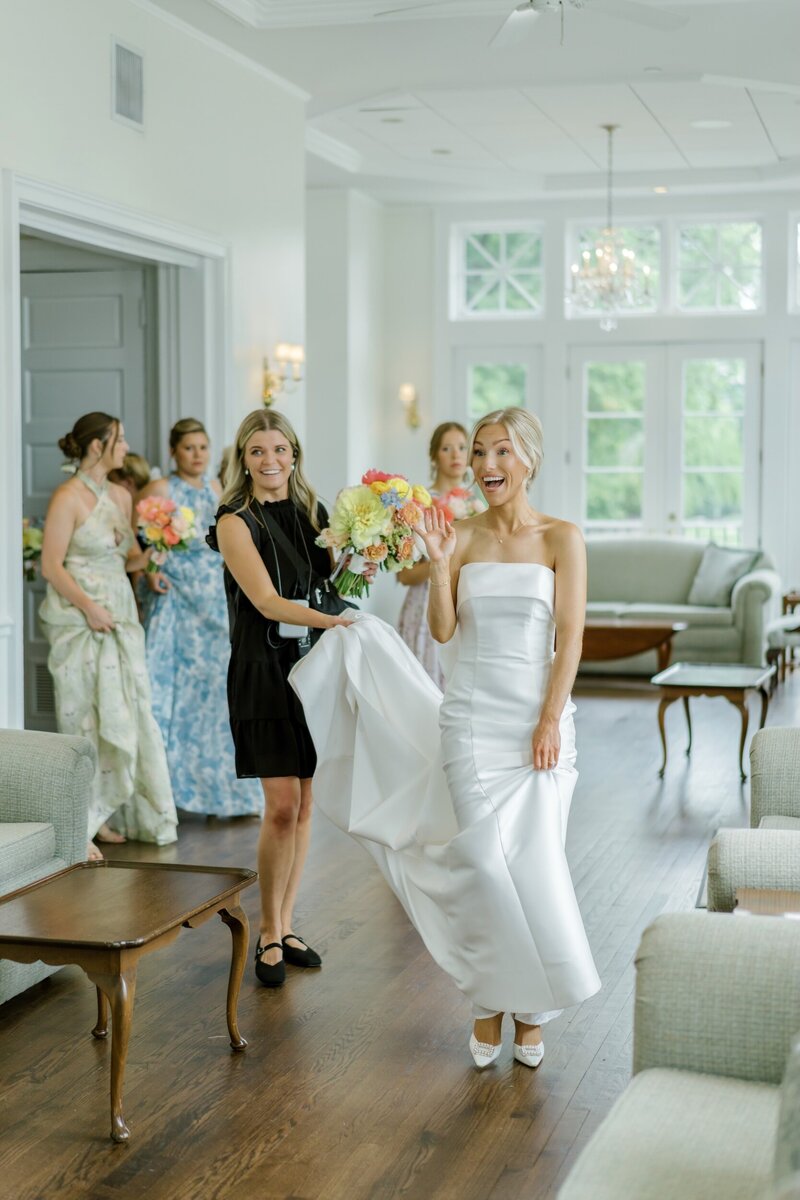 Bride in a white gown smiling with her bridesmaids.