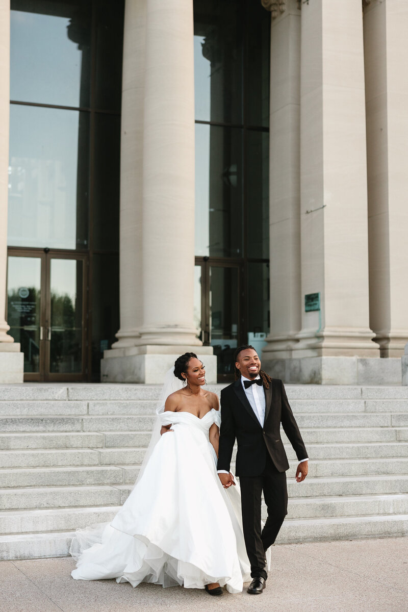 Bride and groom walking in front of St. Louis Art Museum
