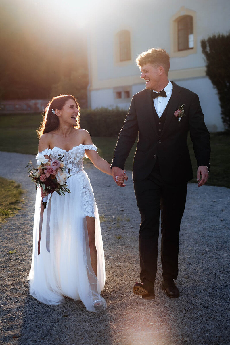 Braut und Bräutigam im warmen Sommerlicht fotografiert im Laufen vor dem Schloss Ehrenfels