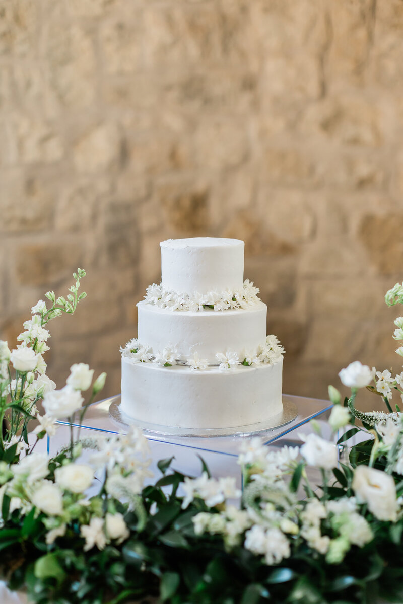 3 tier buttercream cake surrounded by florals at Weinberg at Wixon Valley