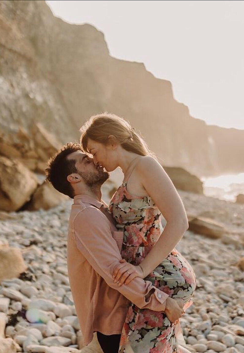 Homme portant une femme sur ses épaules en direction de la mer, scène ludique immortalisée par Laura, photographe en vendée.