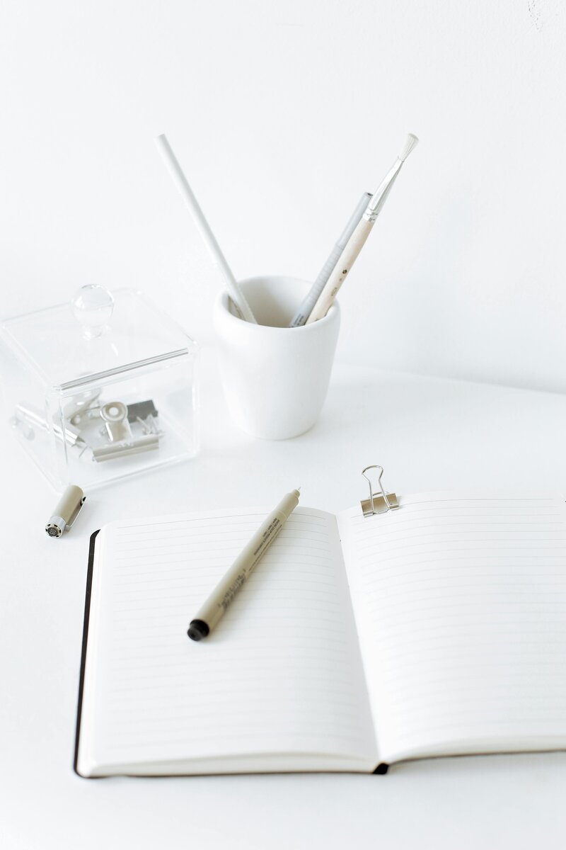 Notebook with a cup of pens and pencils