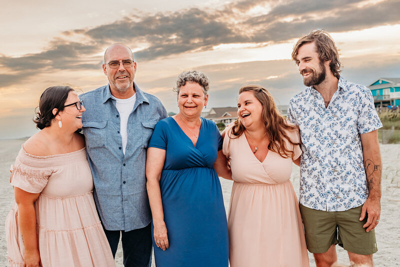dad holding a little boy on his shoulders and his older two sons standing on either side of him for a family photo