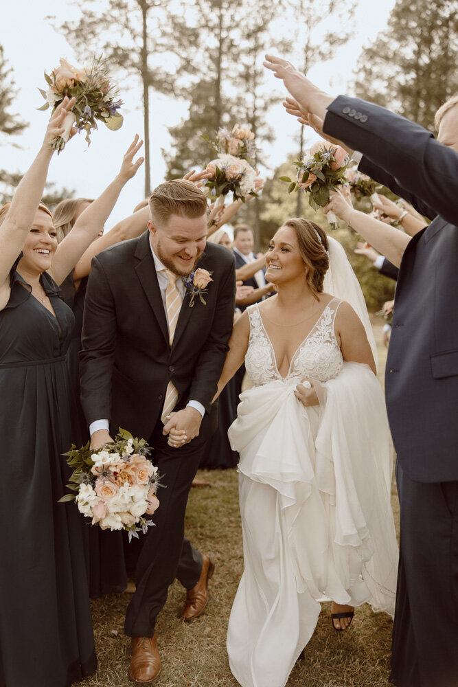 Bride and Groom run through tunnel created by wedding party.