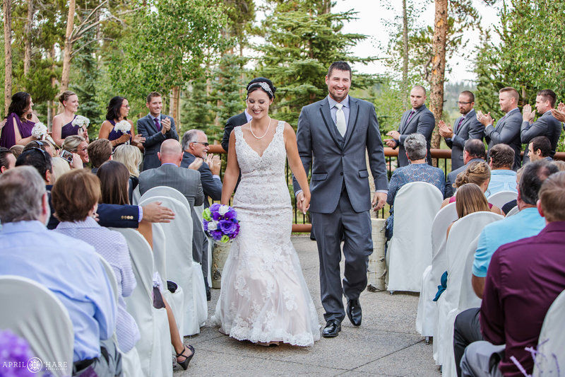 Couples walks hand in hand at the end of their outdoor ceremony at BlueSky Breckenridge