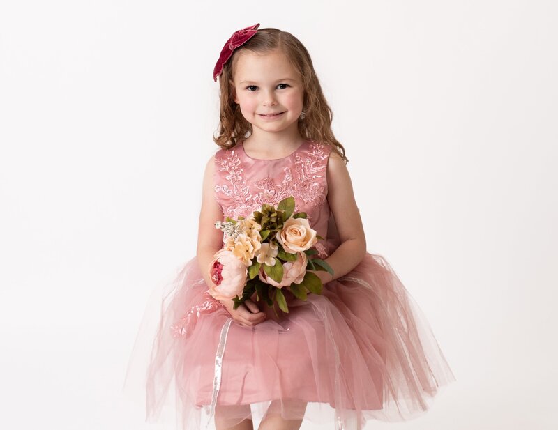 Adorable child in pink dress and flower capture by Houston Photographer
