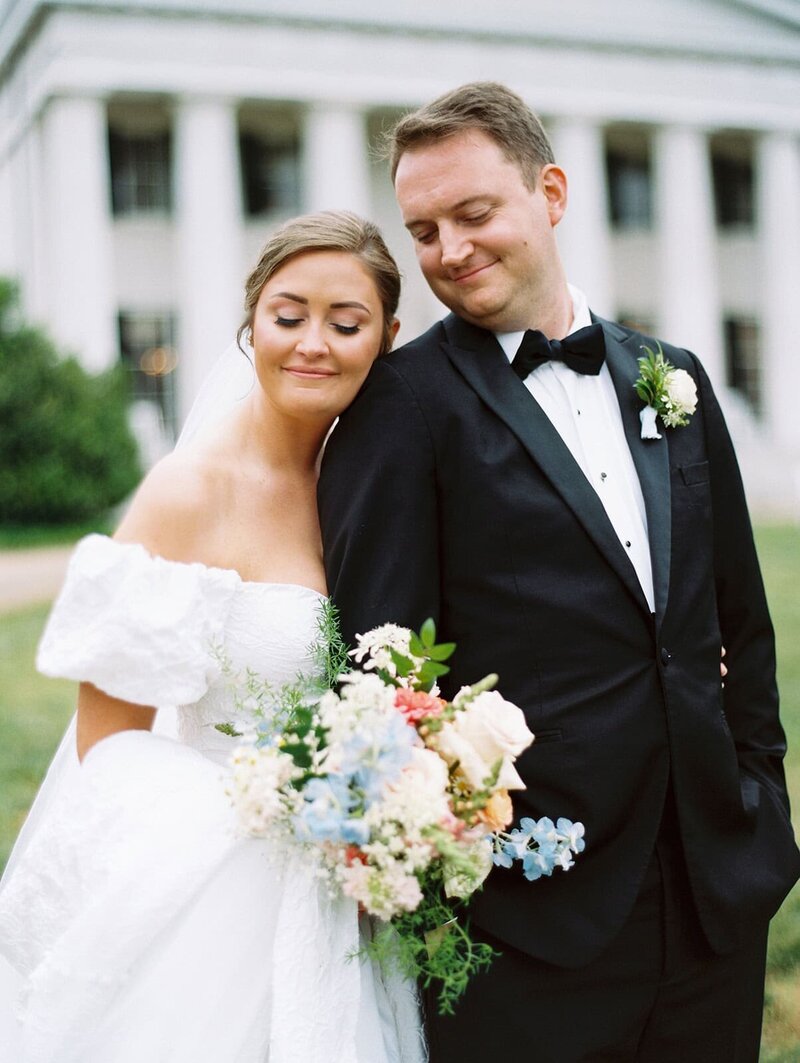 a bride looks over the blue ridge mountains at the swag in waynesville with asheville wedding photographer looking on