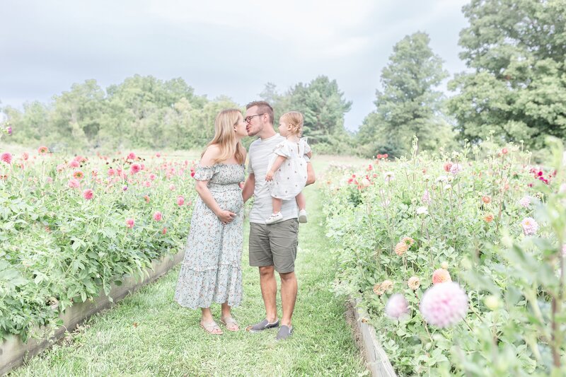 Couple poses in maternity shoot for Ann Arbor Maternity Photographer session location at Muddy Acres Flower Farm
