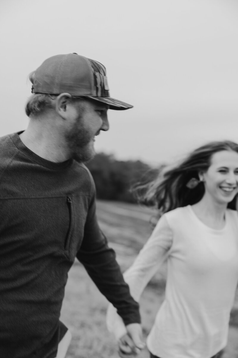 Couple holding hands and running together.