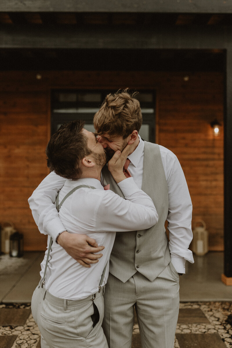 A newlywed couple kissing on an ocean cliff 