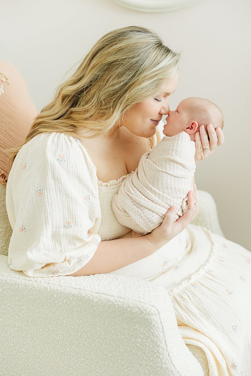 postpartum new mom and newborn baby swaddled with baby registry must haves in Greenville, NC