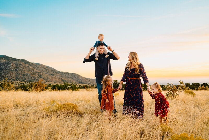 Discover the work of an experienced family photographer in Albuquerque with this beautiful image of expecting parents. Dressed in elegant vintage outfits and standing by a serene lake, they capture a moment of anticipation and joy as they await their new arrival.