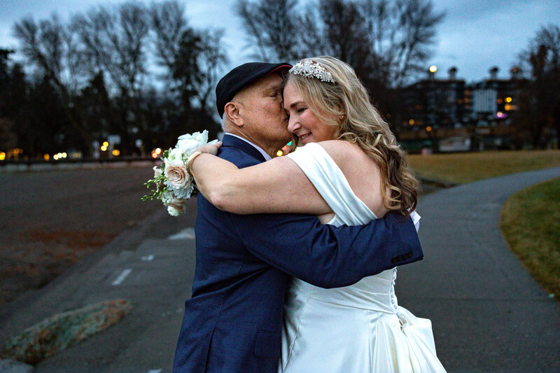 Older couple man in hat bride holding flowers over grooms shoulder smiling.