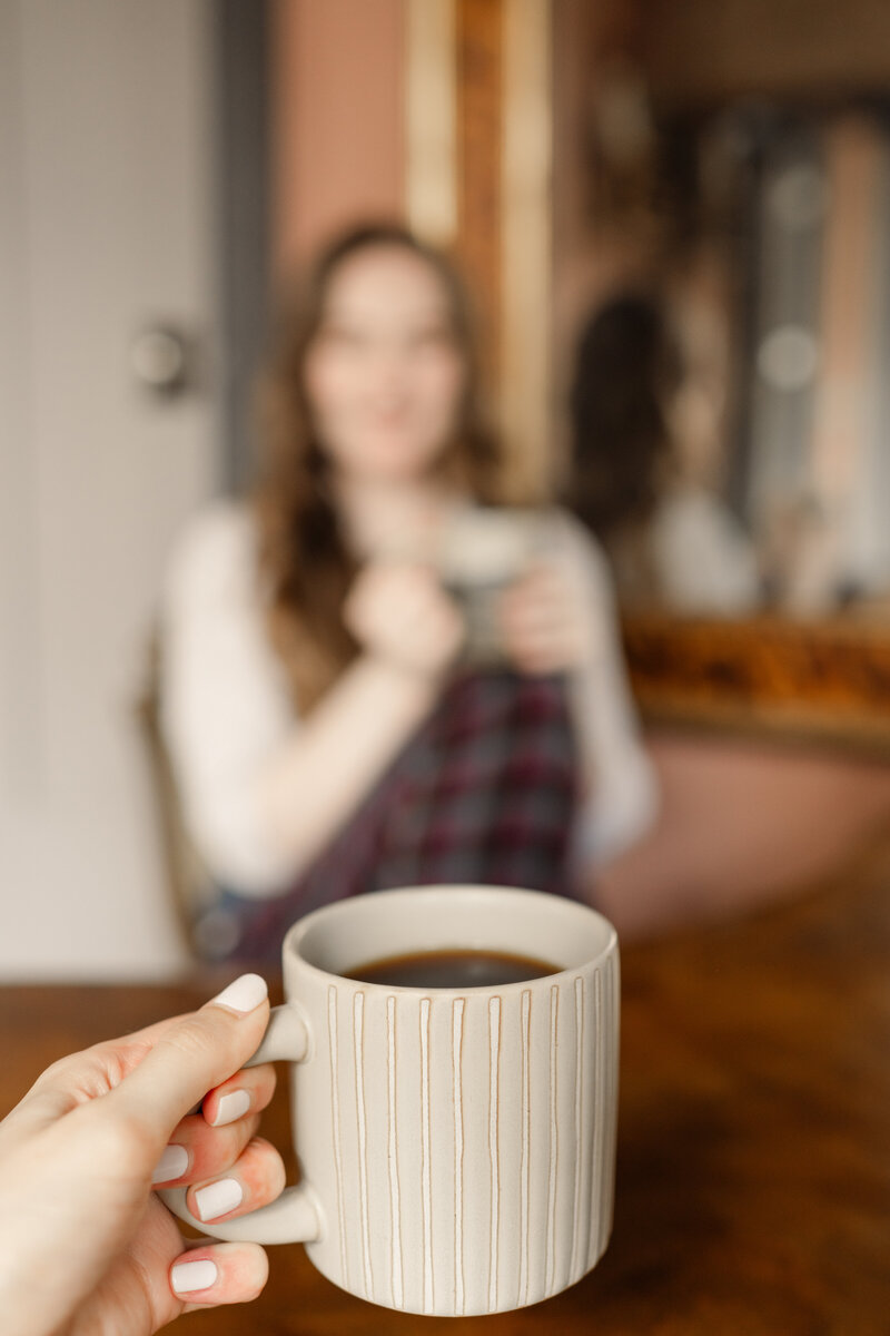 Person is blurred in background, coffee is clear in foreground