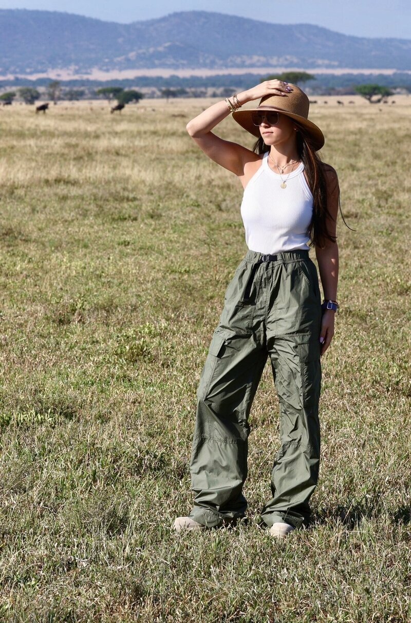 Chaya standing on the African savanna in a wide-brim hat, curator of immersive and high-touch travel experiences.