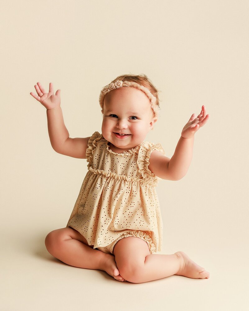 Baby in soft knit bonnet smiling during cozy milestone shoot