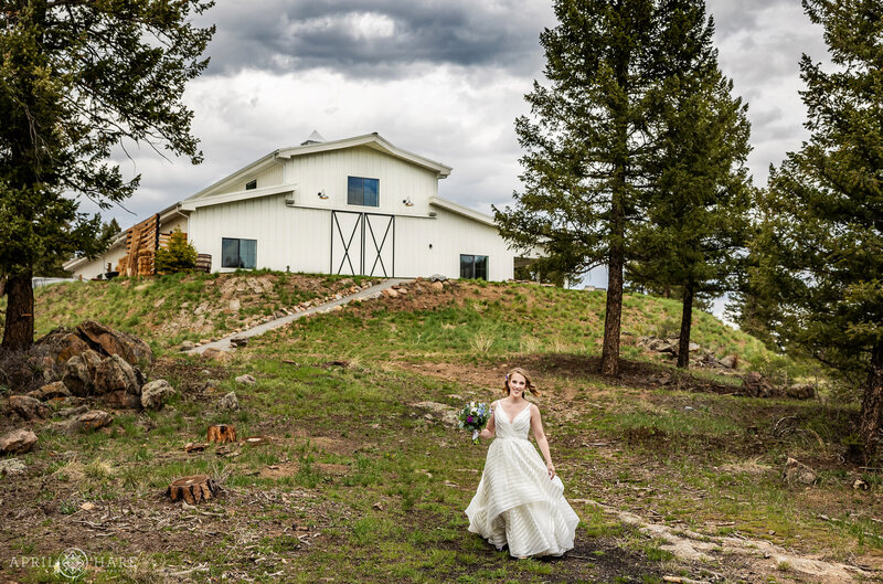 Bride Walks into the Woods at The Woodlands Wedding Venue in Conifer Colorado