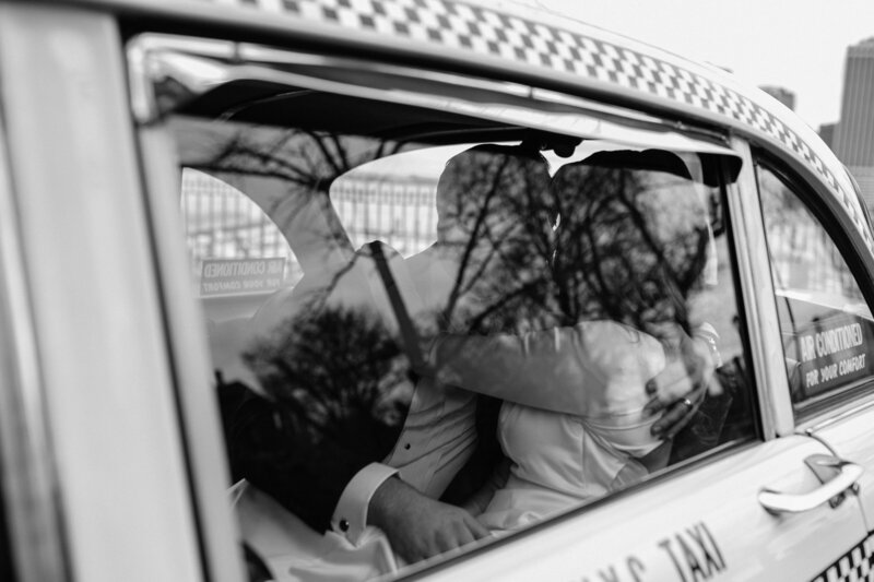 Bride and groom kissing in taxi cab Los Angeles California