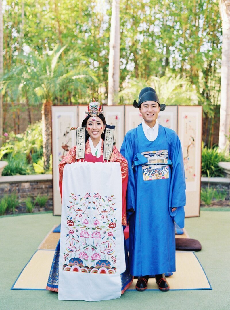 Kohnur couple in traditional Korean Hanbok wedding attire with classic makeup and ceremonial garments in a lush outdoor garden Yorba Linda, California.