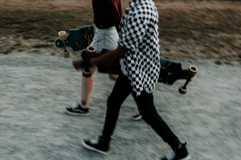teen males walking in black and white with skateboards