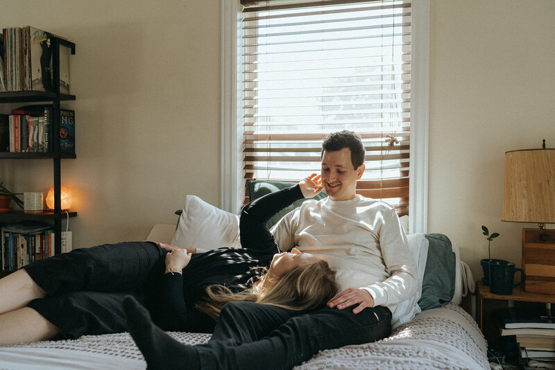 couple lying on bed during at home engagement photos, captured by Elsie Goodman, an NYC engagement and couples photographer