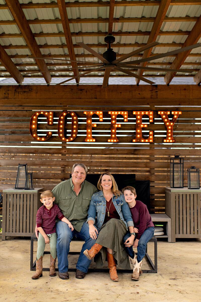 Rugged Portrait of a Family of 4 in their backyard under a custom name sign. Photo taken by Lydia Teague Photography.