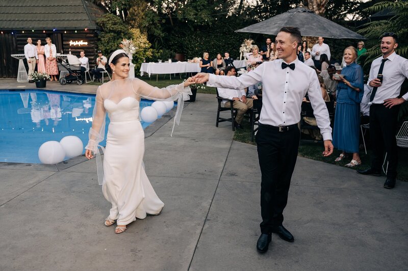 a bride and groom do their first dance beside a pool in their tirsh peng wedding dress in christchurch wedding