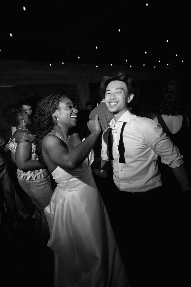 Black and white wedding photo of couple kissing in a old school car
