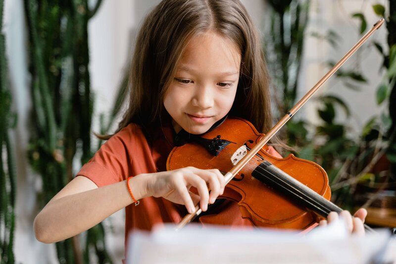 A kid has fun taking violin lessons.