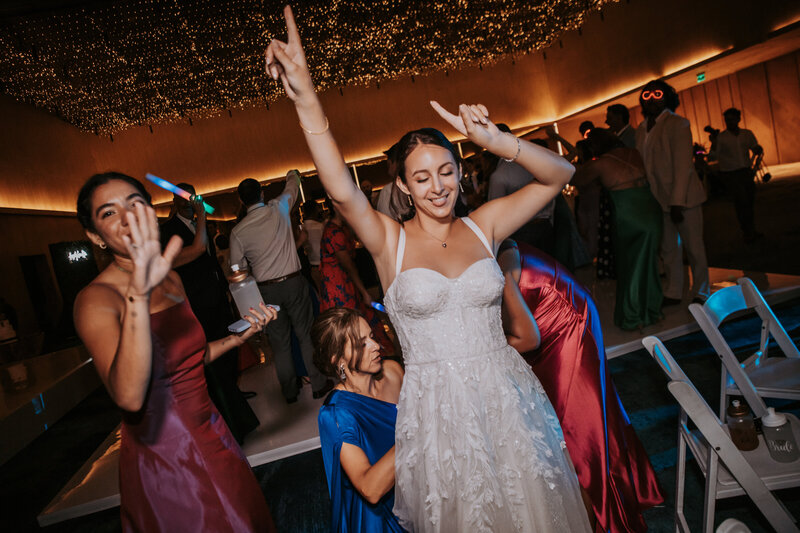 A bride enjoying her wedding reception with friends and family, capturing the joy of a carefully planned destination wedding. Great for promoting destination wedding services and unforgettable group celebrations.