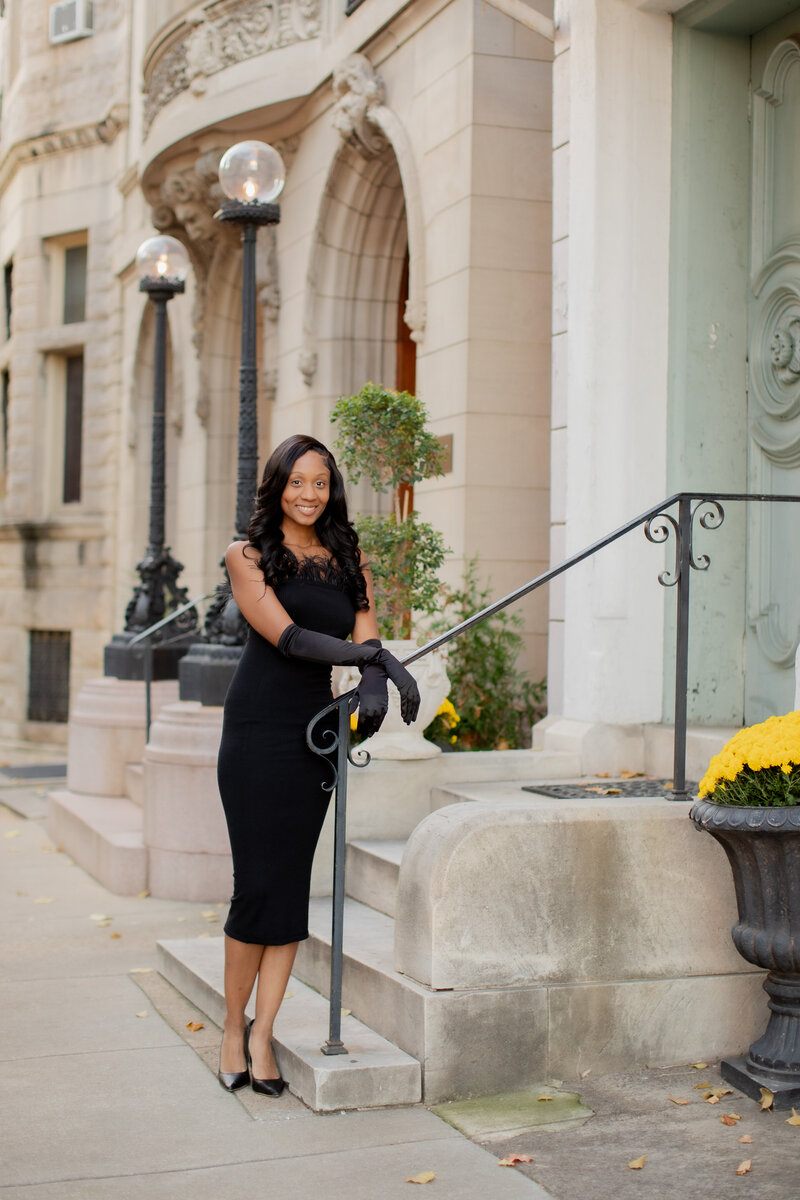 Highschool senior girl posing in front on fountain with short dress