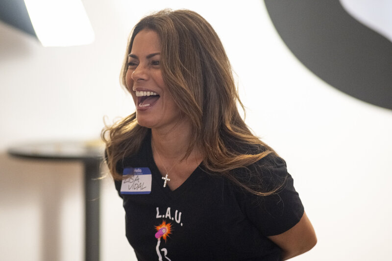 Actress Lisa Vidal, co-founder of Latinas Acting Up, smiling and wearing LAU t-shirt and name tag at a community event focused on Latina leadership and creative empowerment.
