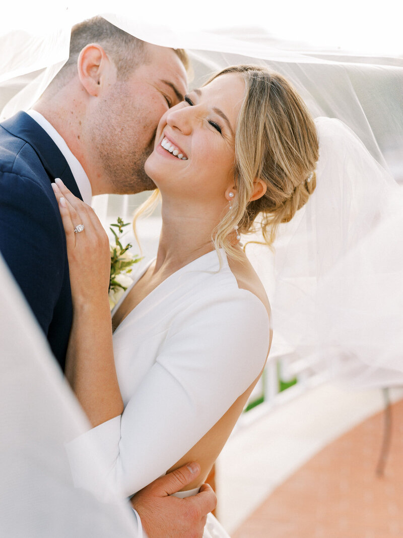 Groom kissing the bride in their sunset wedding photoshoot at Sherwood Country Club, a luxurious wedding venue in San Luis Obispo