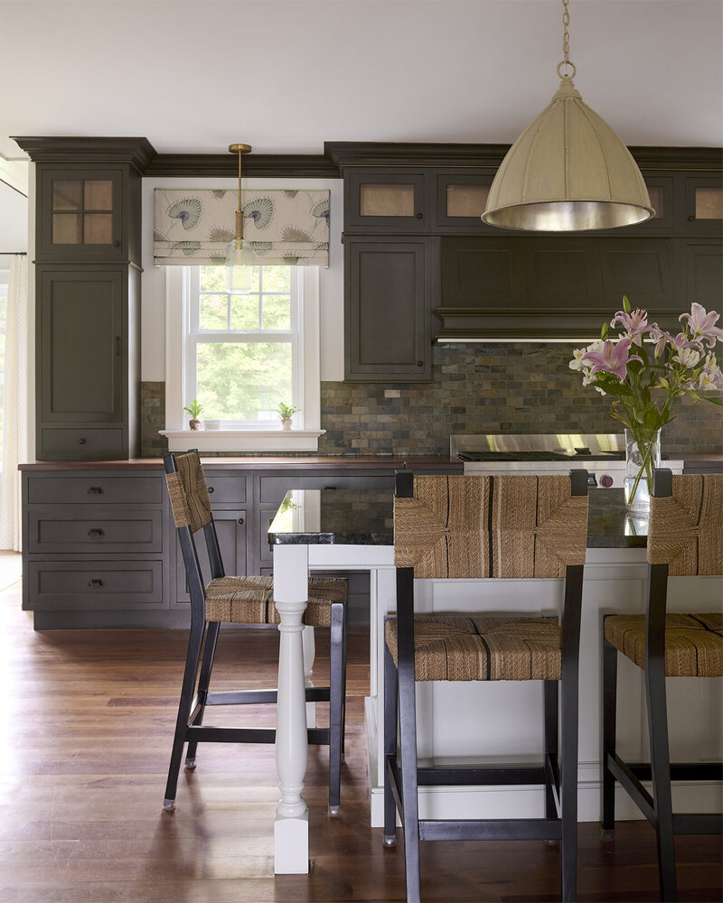 colorful window seat with two brown armchairs and a chandelier