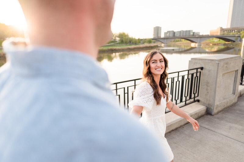 An engaged couple walk along the Scioto Mile in downtown Columbus during their engagement session
