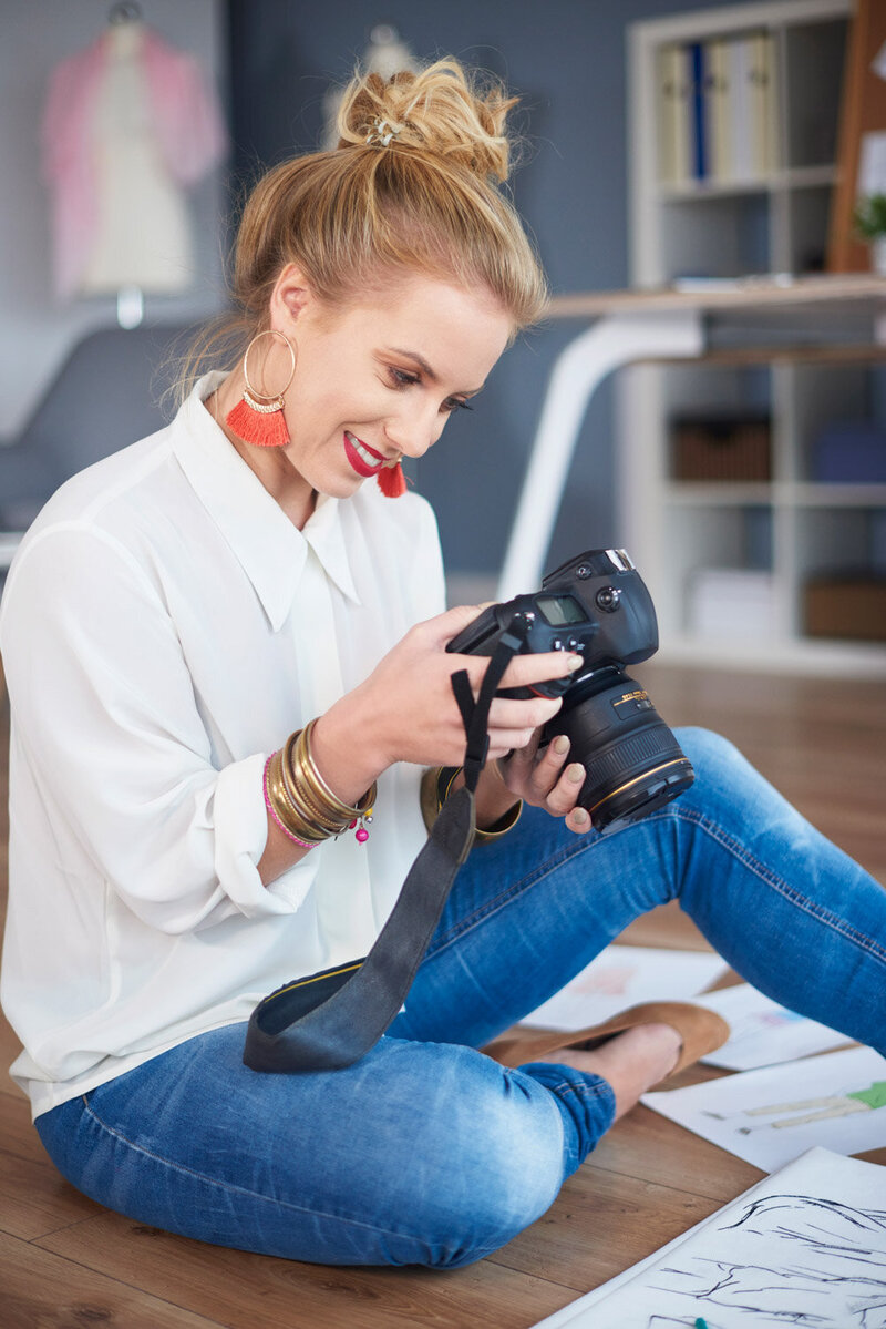 Woman in a red dress smiling at her laptop