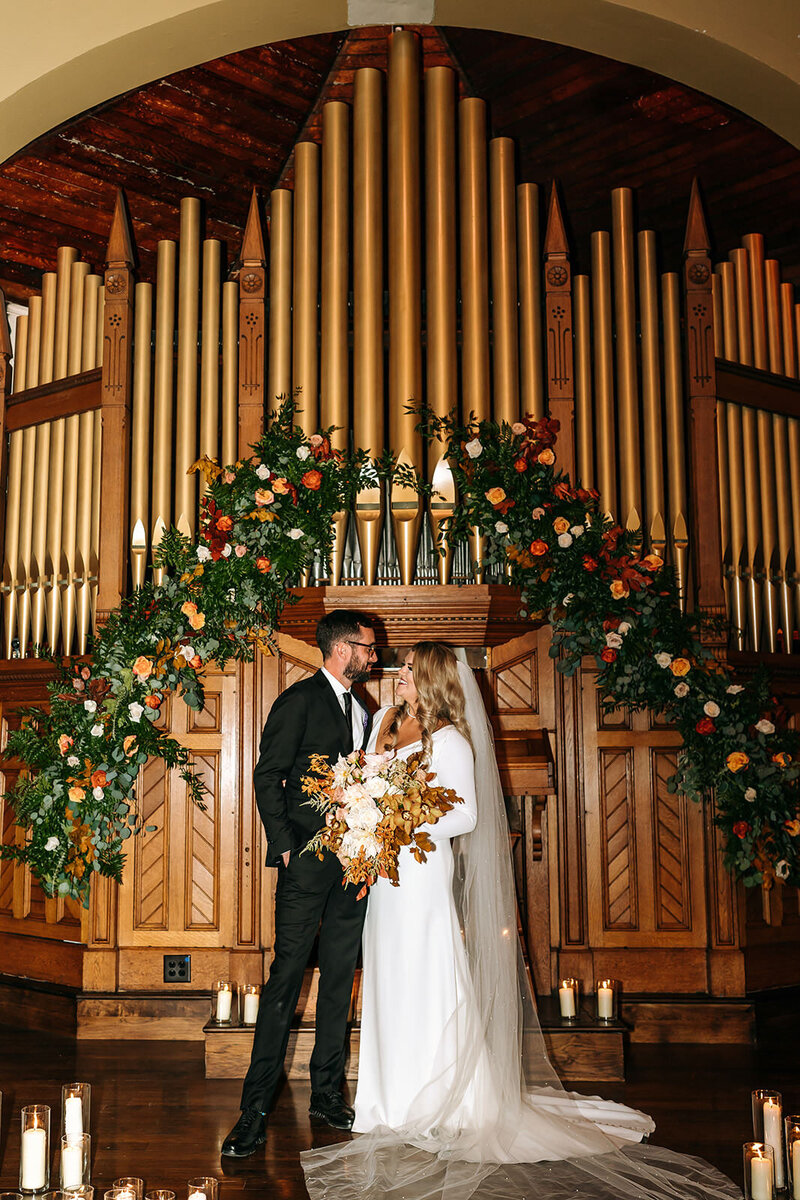 bride and groom in front of organ