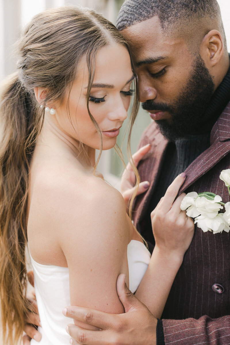 Editorial wedding portrait of a modern couple sharing a joyful moment, featuring a fashion-forward satin bridal outfit and effortless luxury styling. Fresno CA at The Grand 1401 venue.