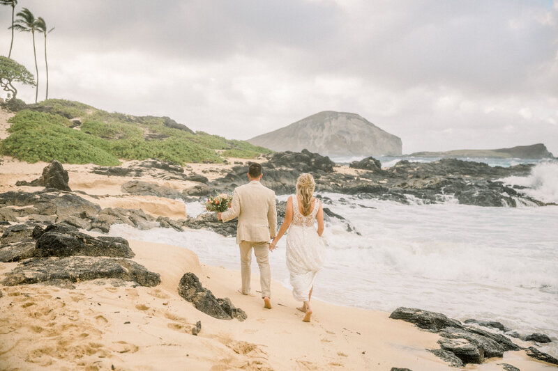 wedding day portrait of couple walking on the beach in Oahu Hawaii