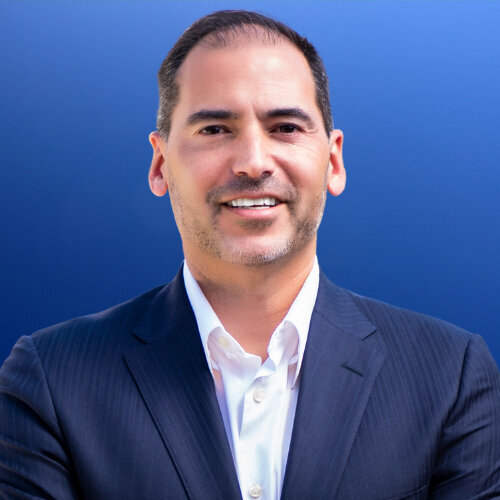 Real Estate agent headshot with a blue  background Jason Lopez  best real estate agent  in Orange County