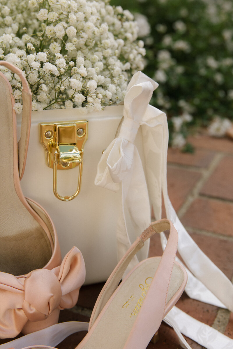BRIDAL DETAILS WITH WHITE BOW AND PINK HEELS
