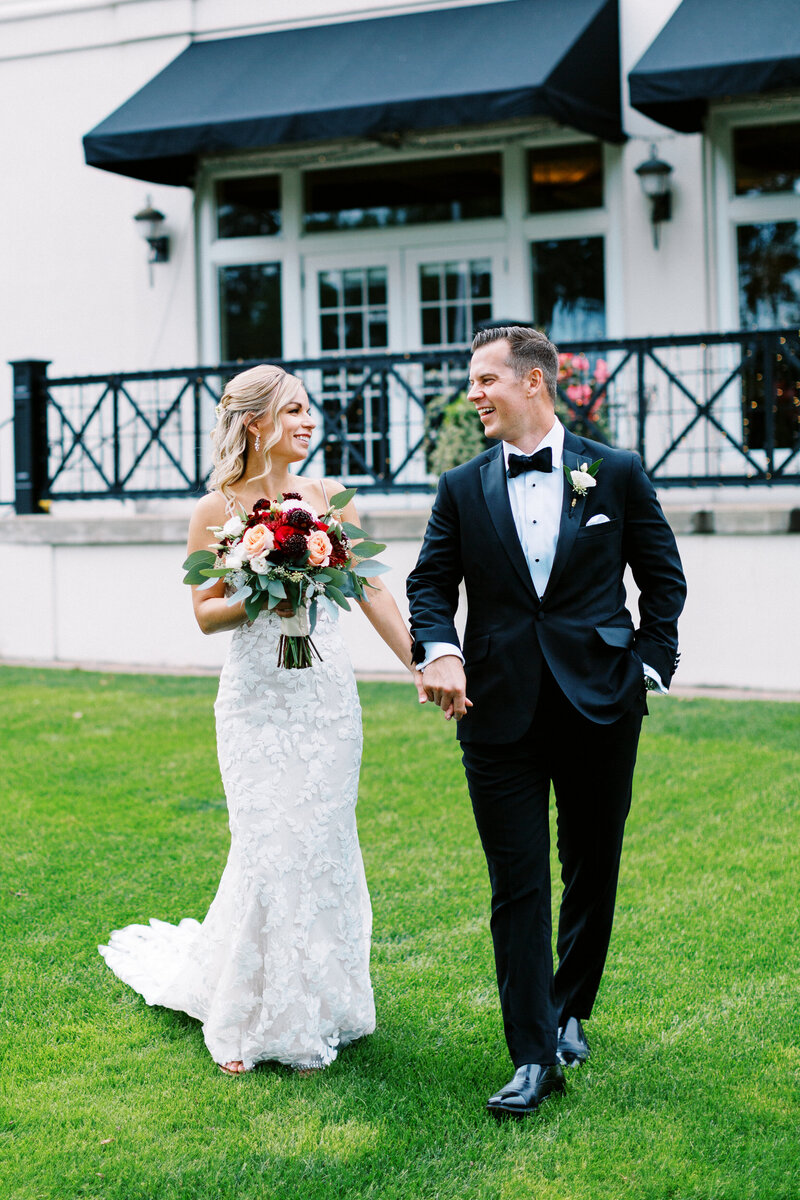 Newlyweds joyfully walking and looking at each other smiling