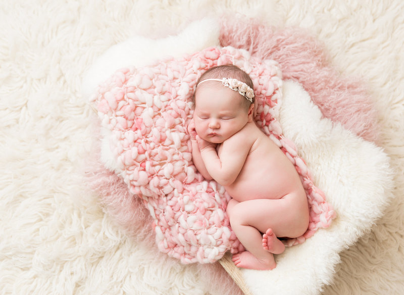 baby girl in pink knit blnaket