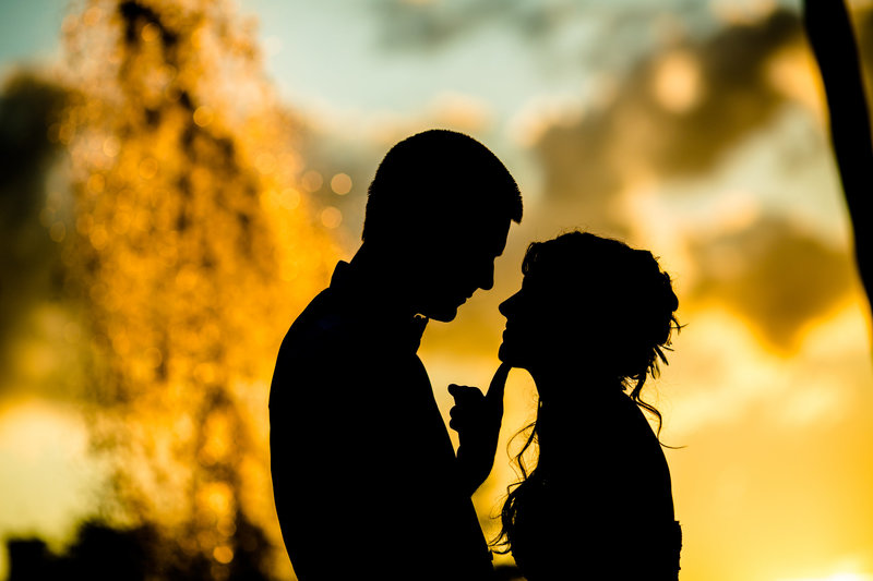 Romantic wedding silhouette of a couple framed by a glowing sunset and fountain at Valley Forge.