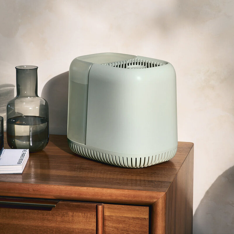 A humidifier sitting on a night stand.