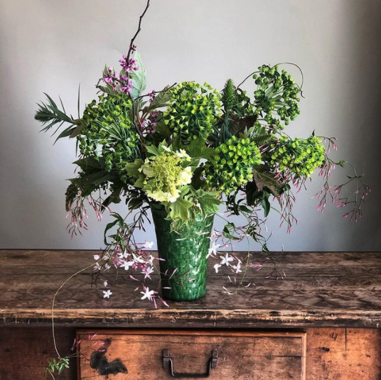 Green floral arrangement in a green vase