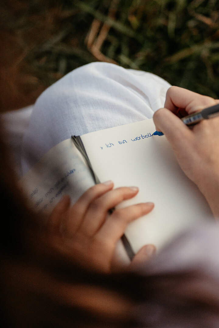 Nahaufnahme von Tessa Adrian, die in der Natur lacht, voller Freude und Gelassenheit.