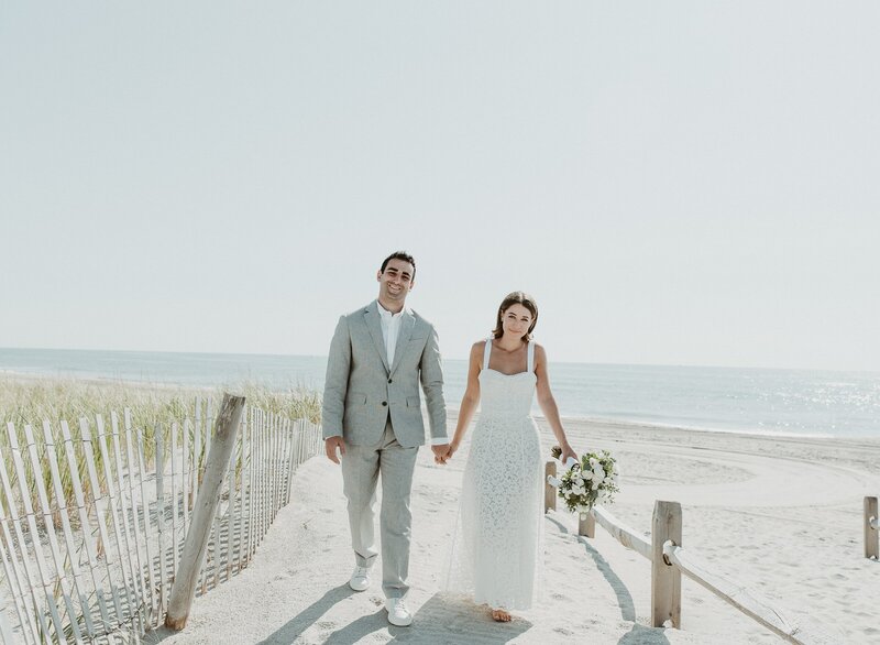 bride and groom walking on beach at wedding in malibu